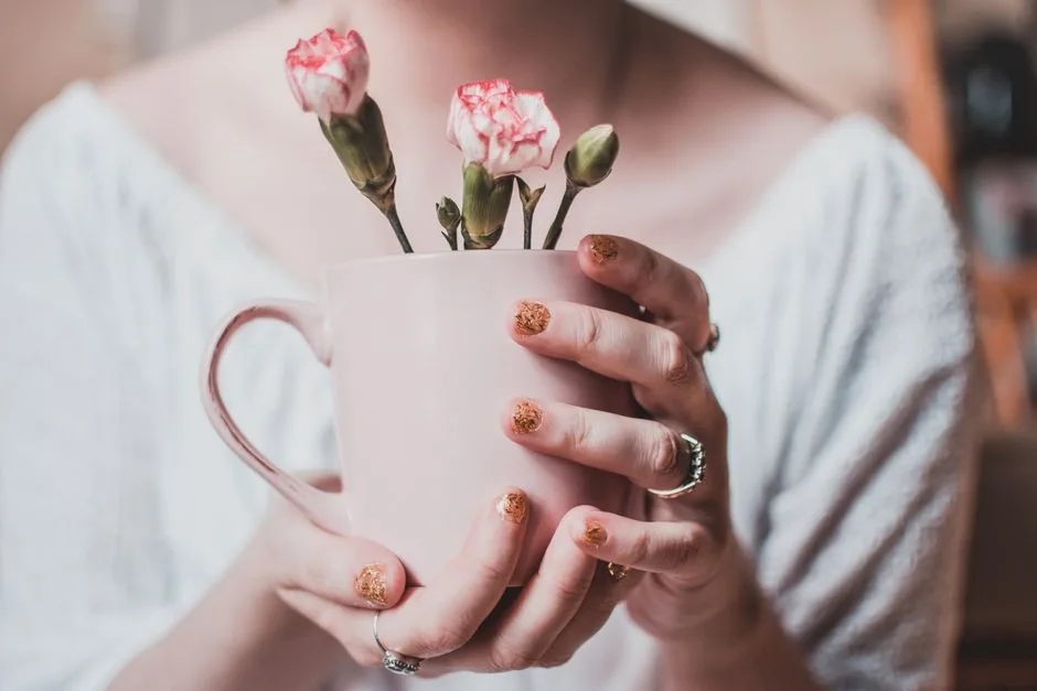 Glitter negle i pink toner med pink keramisk kop og blomster